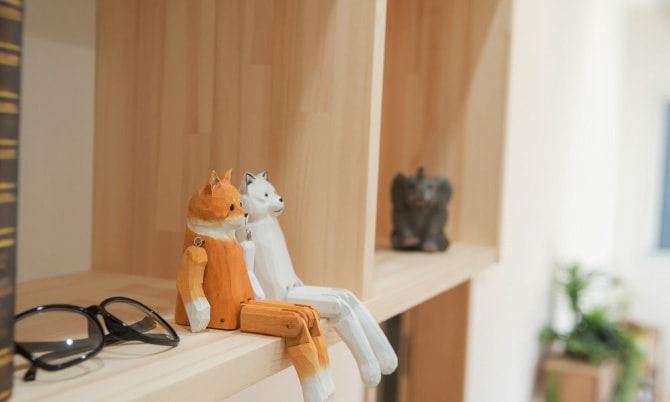 小さな動物の人形や眼鏡が置かれた木製の棚